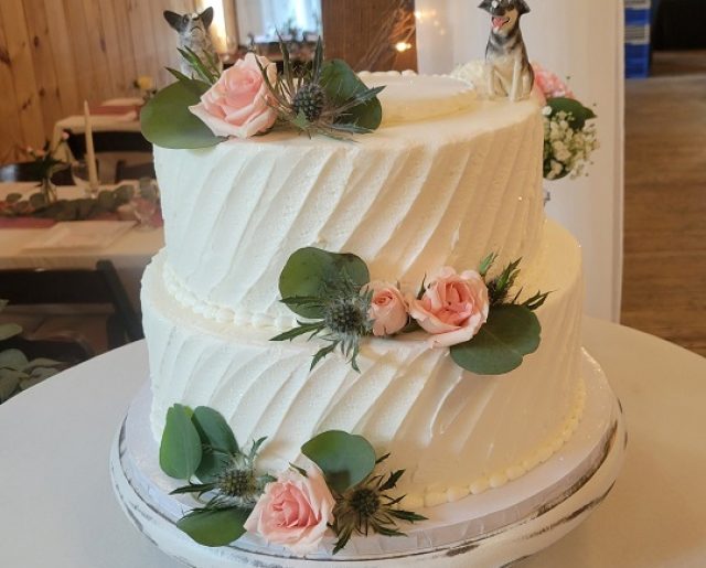 white floral tiered wedding cake with dogs