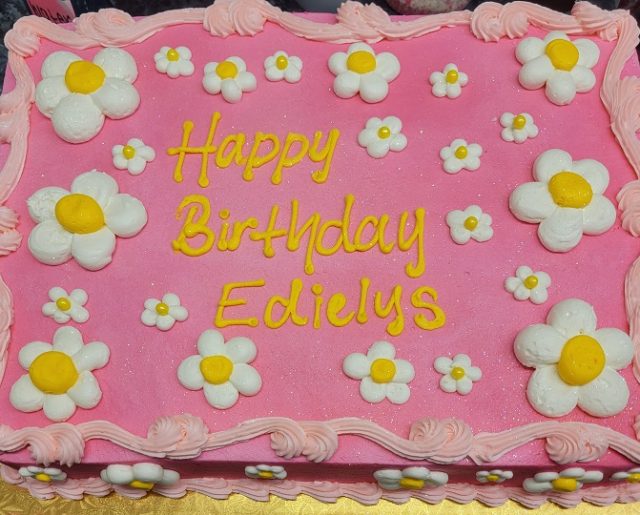 pink sheet birthday cake with daisies
